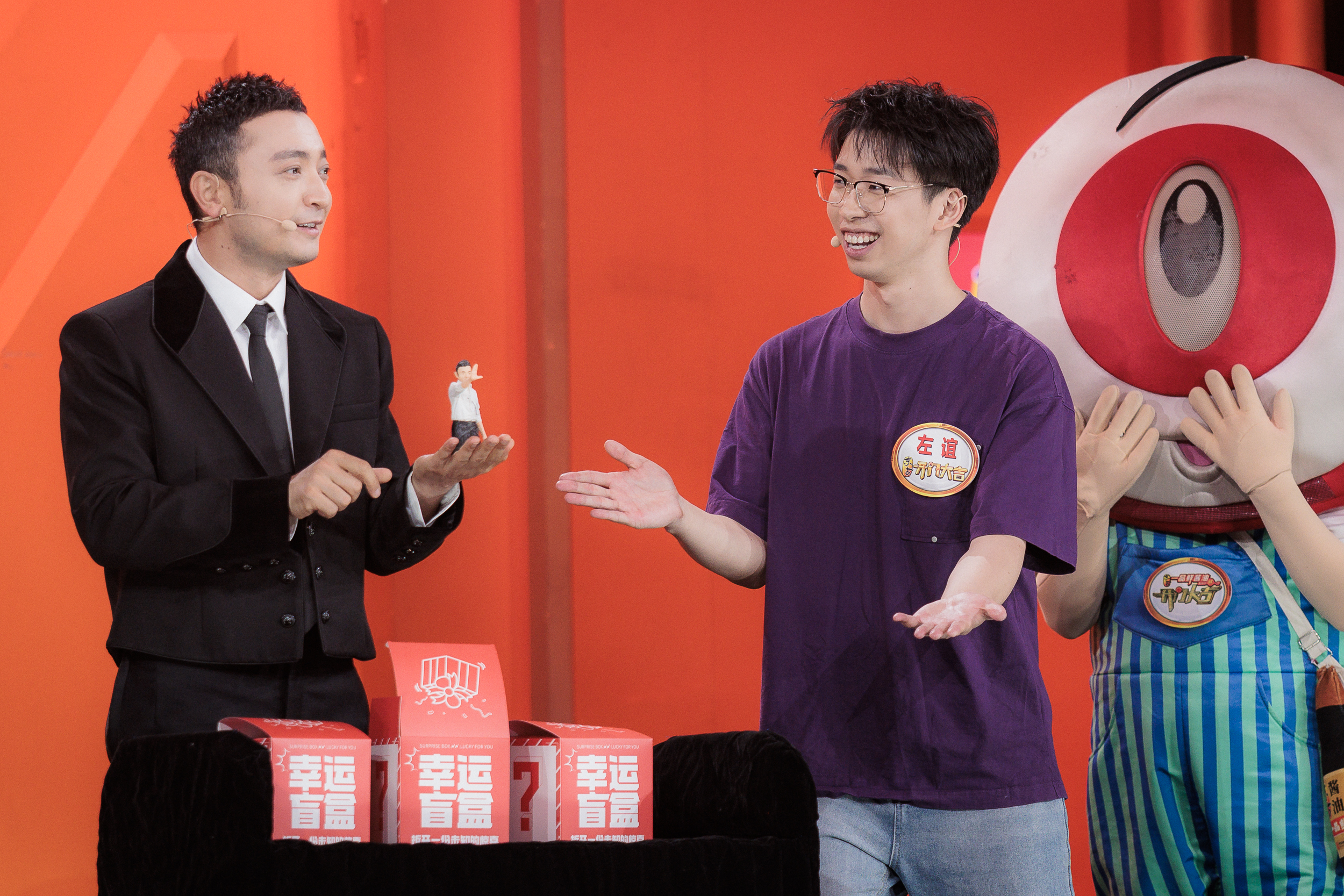 Yi Zuo on CCTV’s Kai Men Da Ji with a miniature character figure