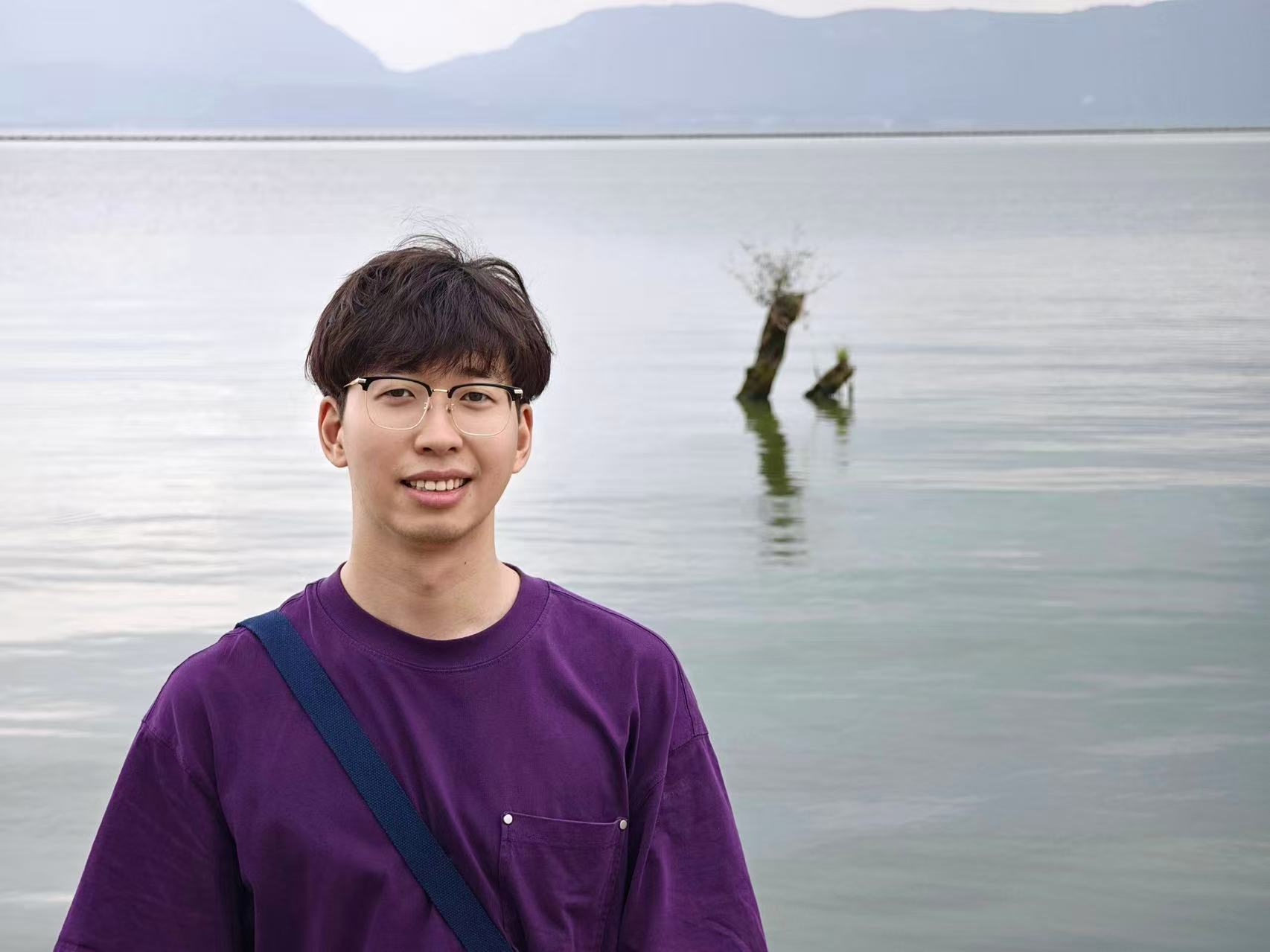 Yi Zuo standing beside a lake
